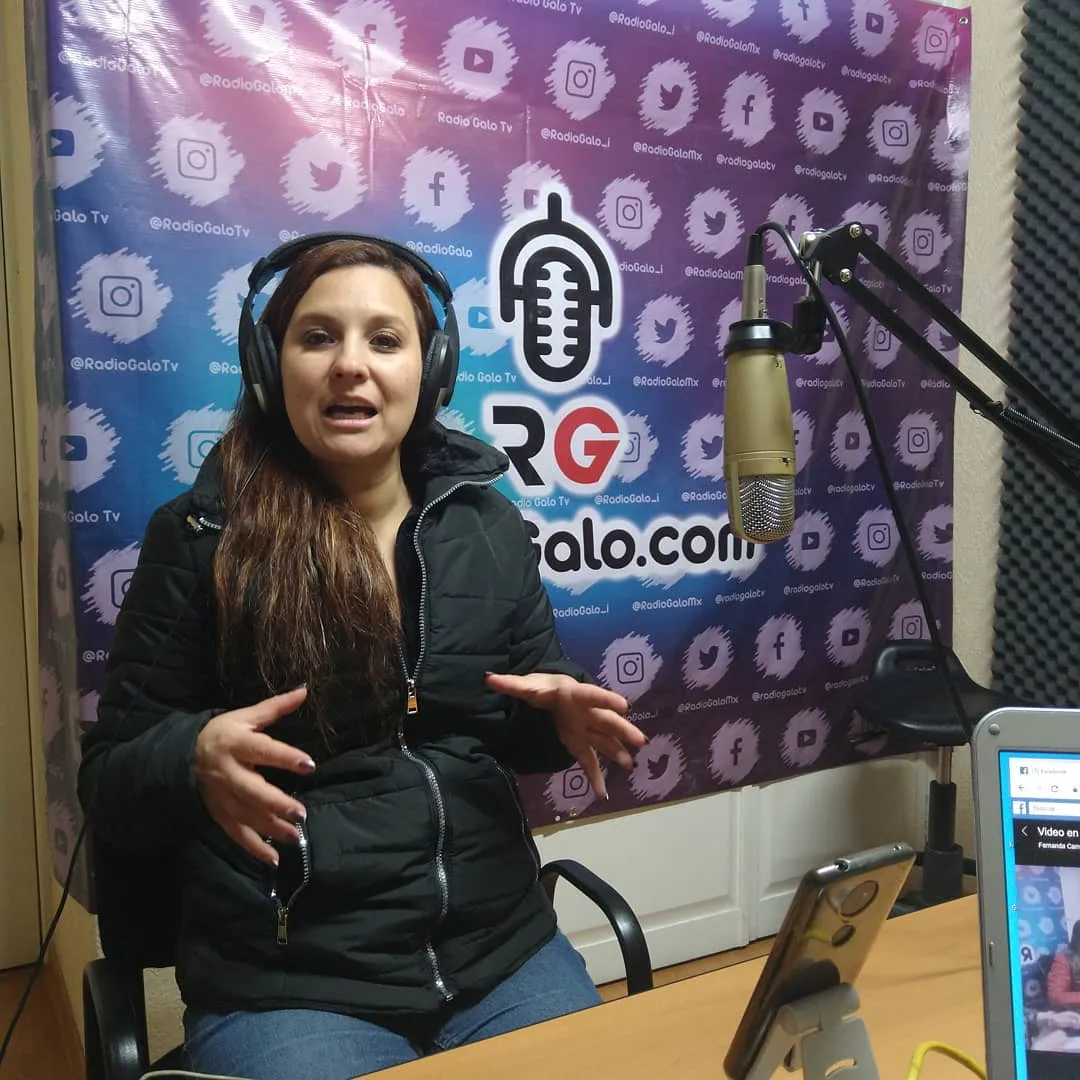 Invitada hablando en la cabina frente al fondo de RadioGalo.com