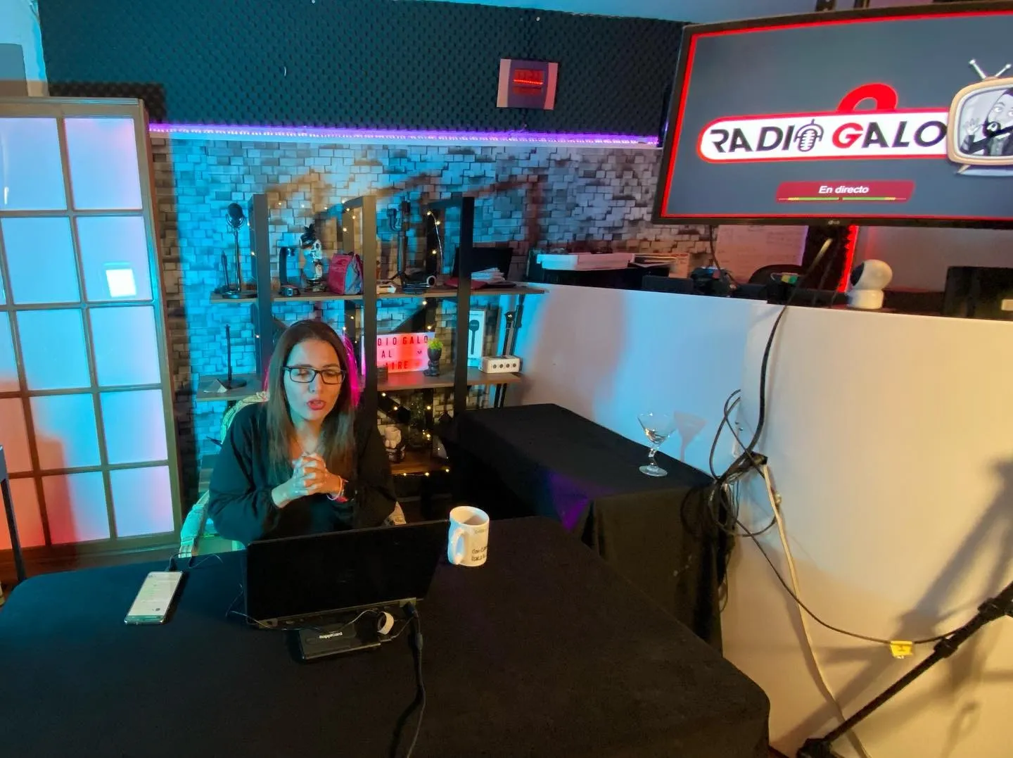Conductora en la mesa de la cabina con la consola y el letrero de Radio Galo