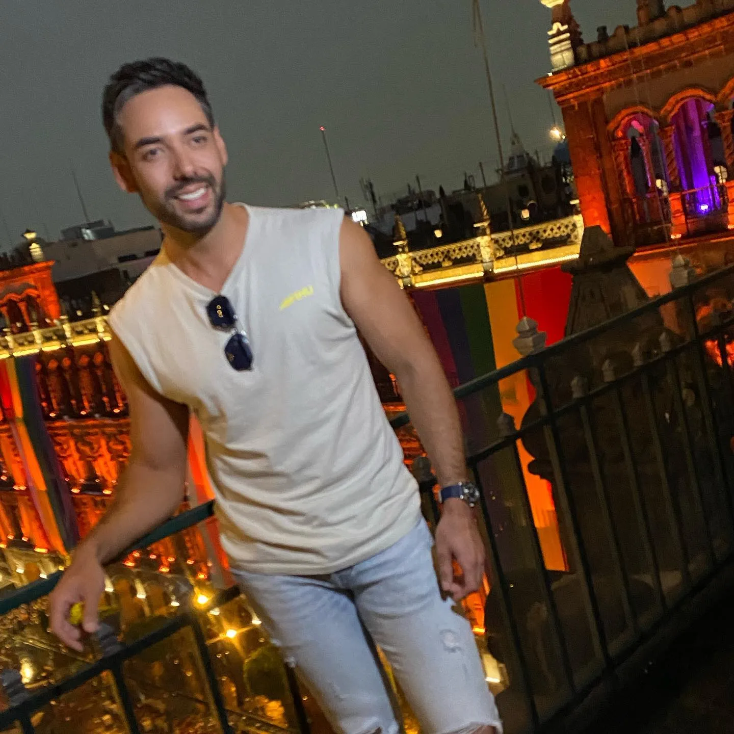 Hombre sonriendo en una terraza de noche con la Catedral iluminada al fondo