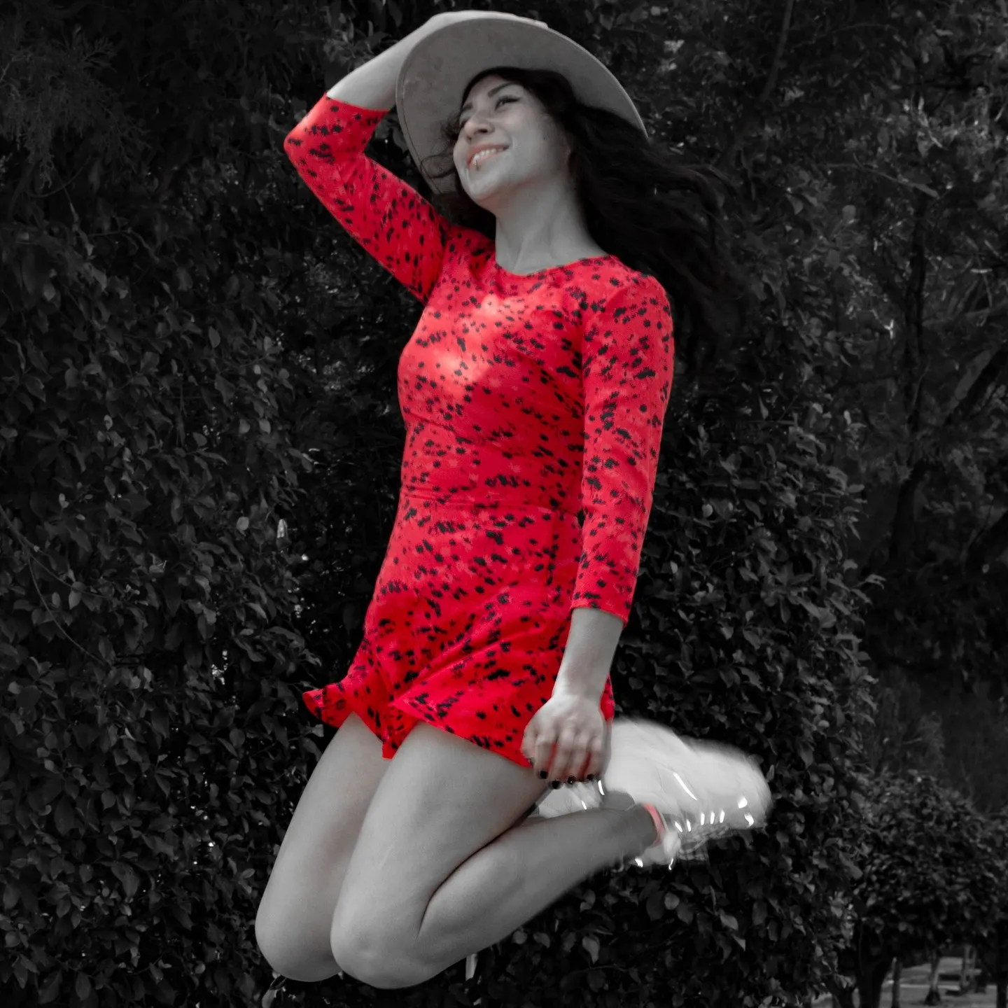 Mujer con vestido rojo saltando, foto en blanco y negro con el vestido a color