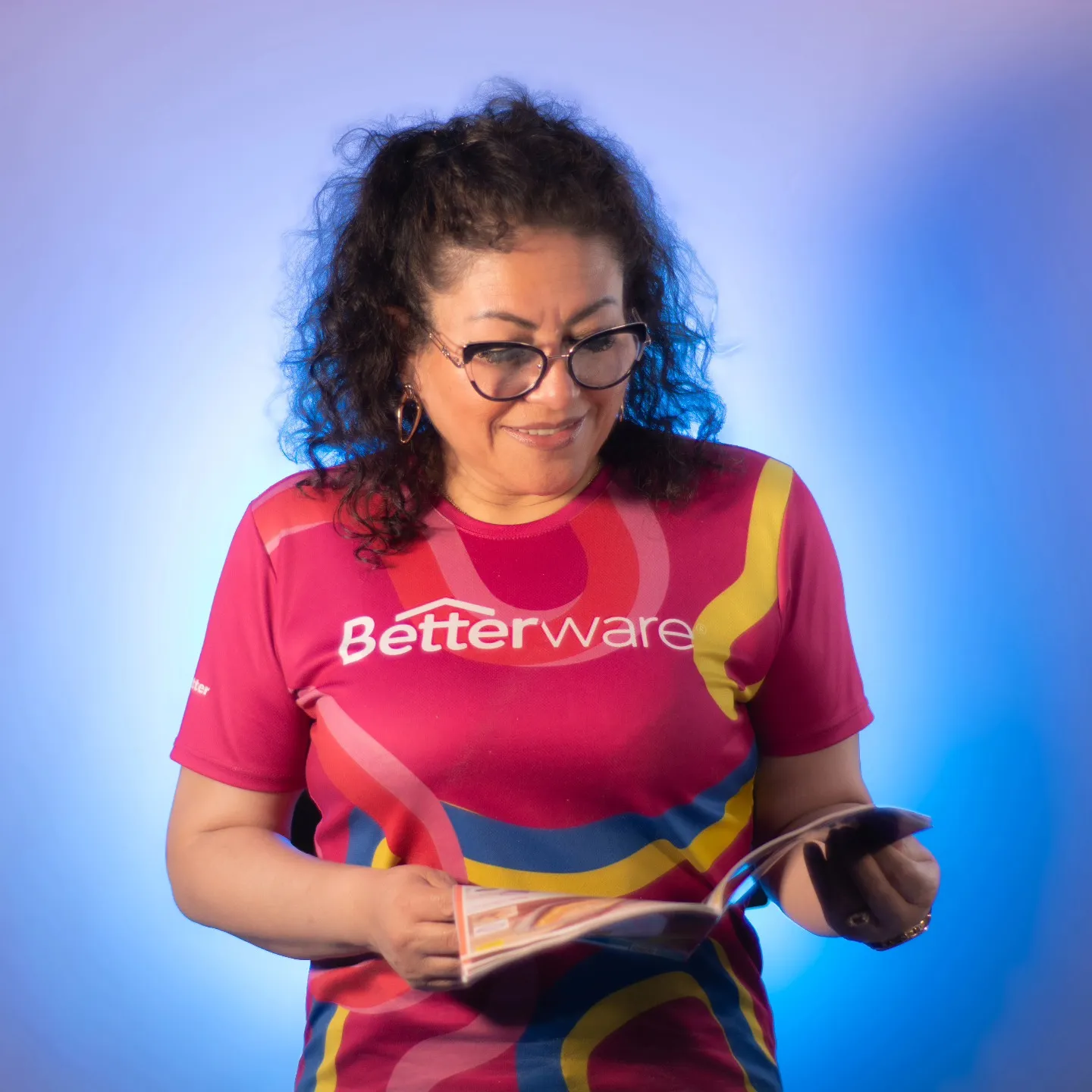 Retrato de estudio de una emprendedora con playera de Betterware sobre fondo azul